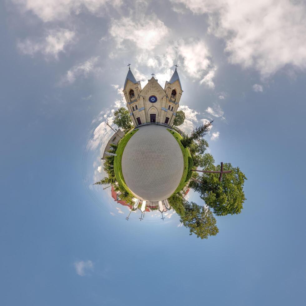 little planet transformation of spherical panorama 360 degrees overlooking church in center of globe in blue sky. Spherical abstract aerial view with curvature of space. photo