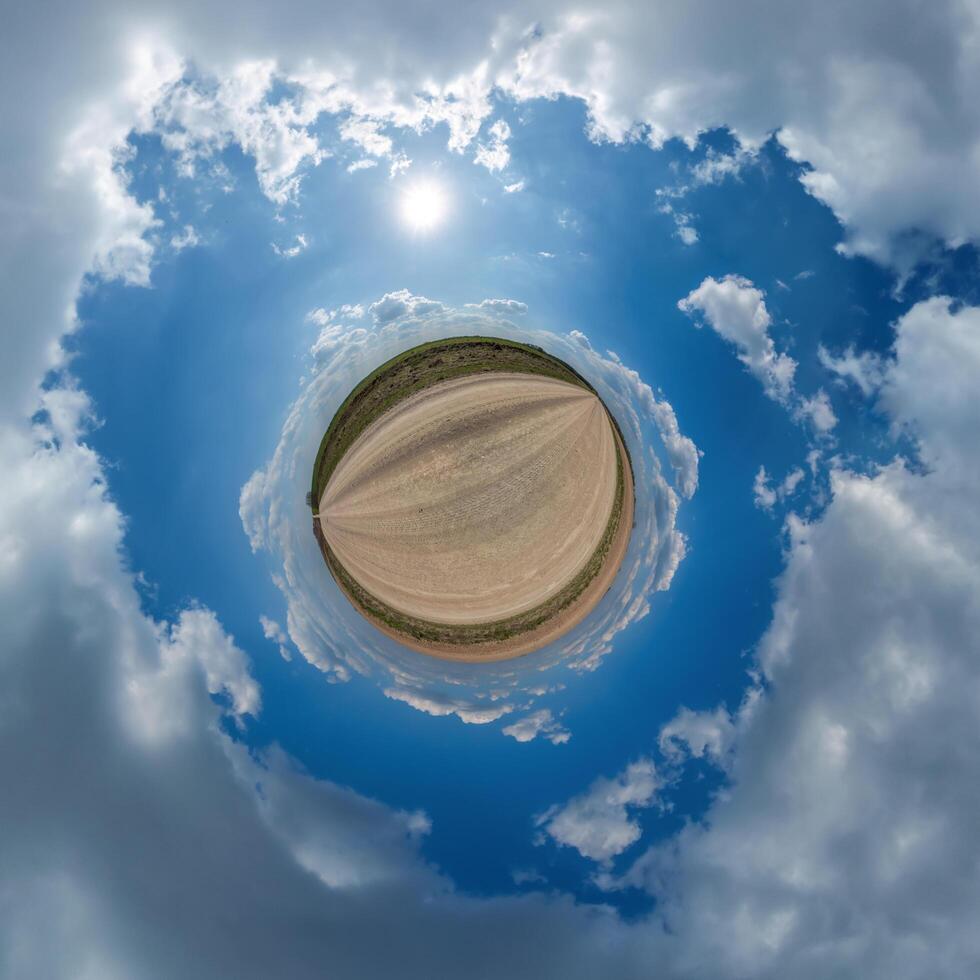 simple tiny planet without buildings in blue sky with beautiful clouds. Transformation of spherical panorama 360 degrees. Spherical abstract aerial view. Curvature of space. photo