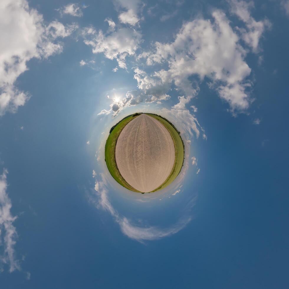 simple tiny planet without buildings in blue sky with beautiful clouds. Transformation of spherical panorama 360 degrees. Spherical abstract aerial view. Curvature of space. photo