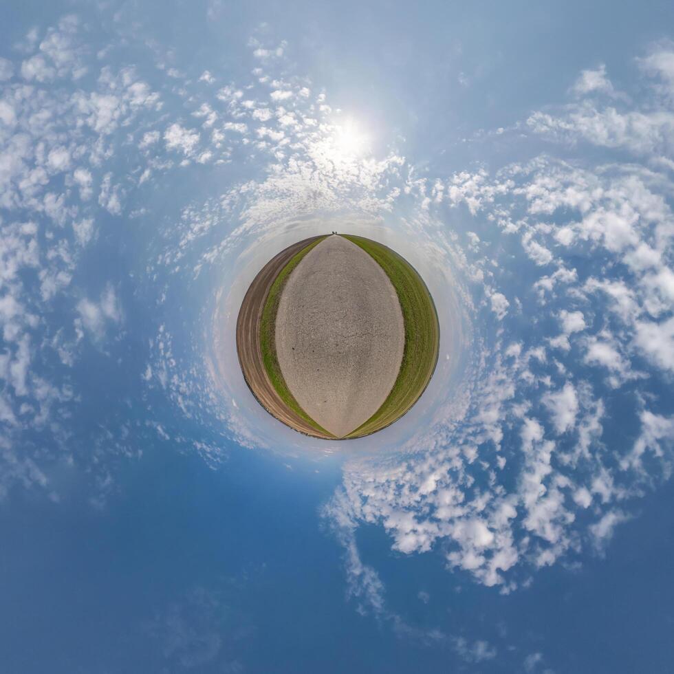 simple tiny planet without buildings in blue sky with beautiful clouds. Transformation of spherical panorama 360 degrees. Spherical abstract aerial view. Curvature of space. photo