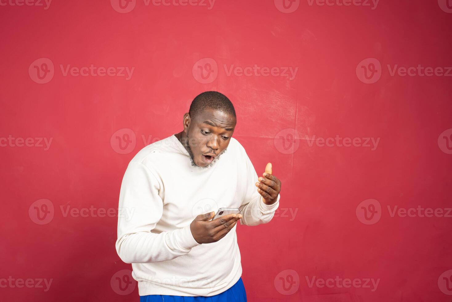 Portrait of a joyful young man holding mobile phone photo