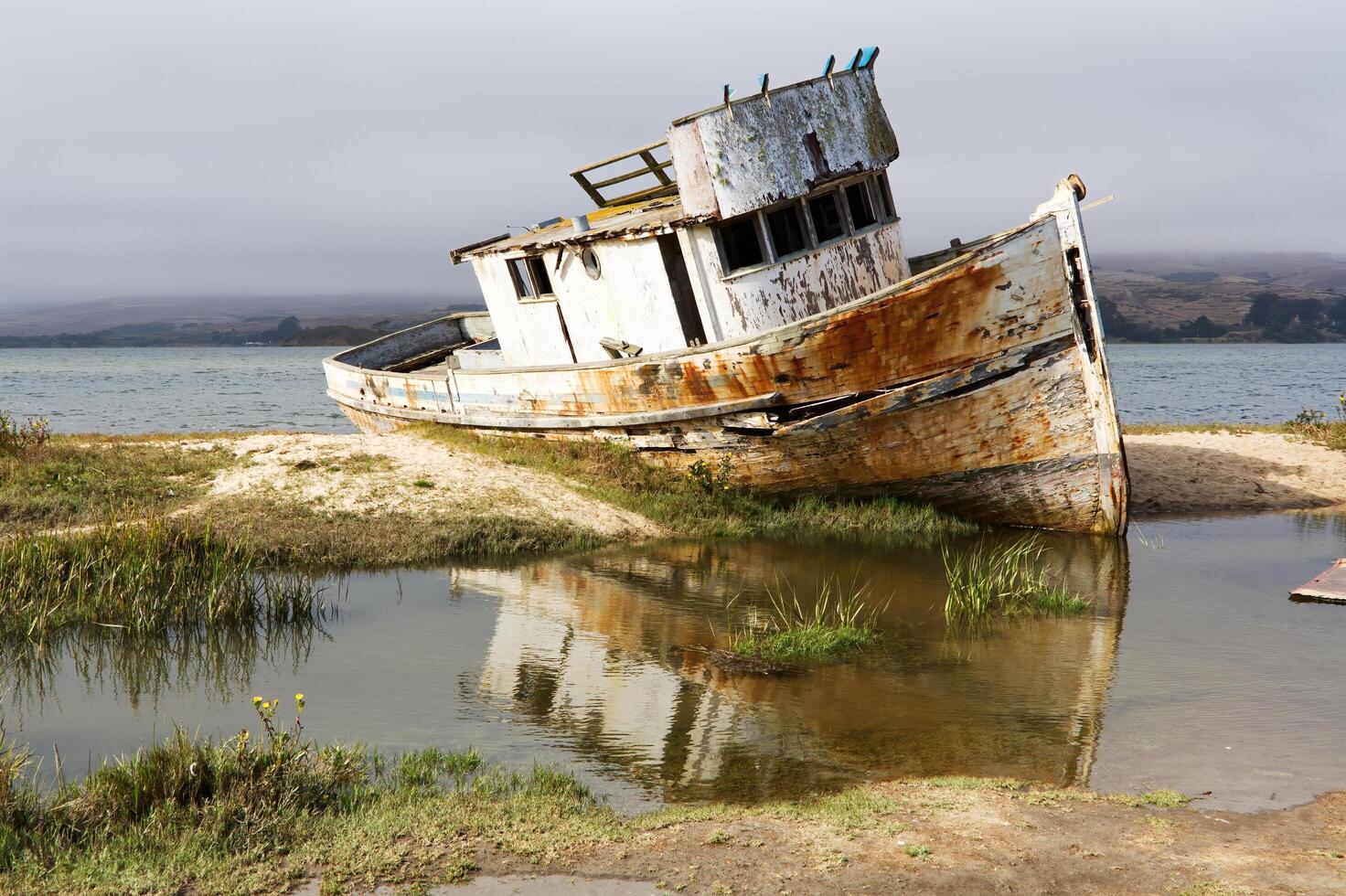 Point Reyes, CA, 2014 - Abandoned Wooden Fishing Boat On Shore Overcast Sky photo