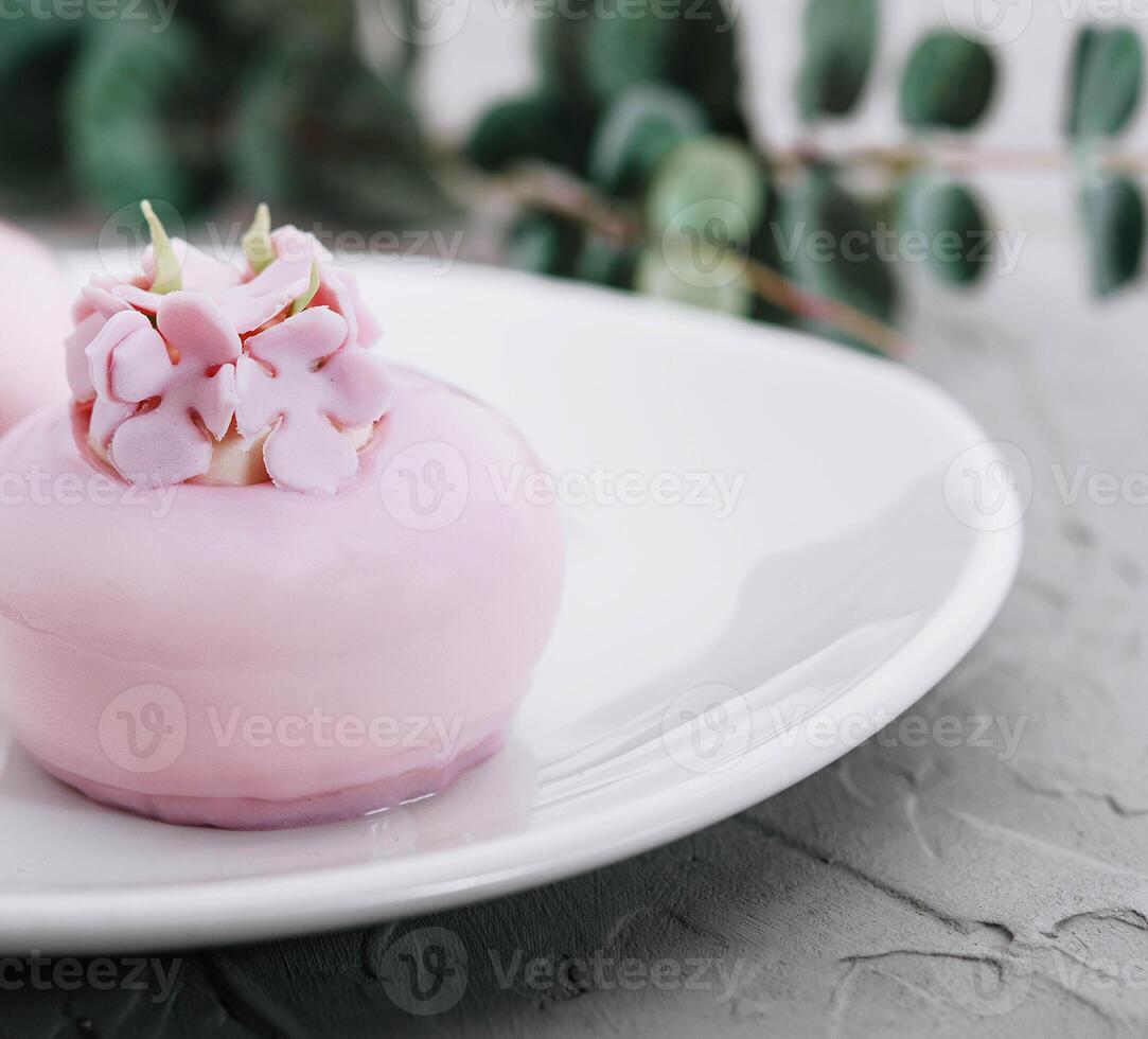 rosado mousse pasteles decorado en blanco plato foto