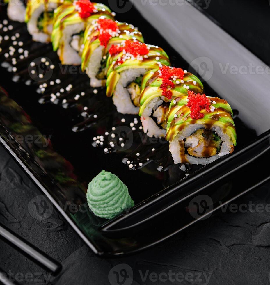 Avocado Sushi roll japanese food on black plate photo