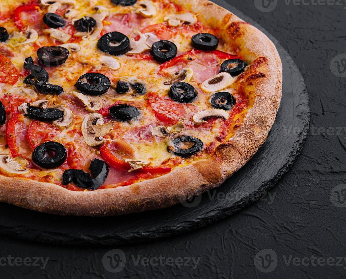 Pizza with tomato, olives, champignons, ham and cheese photo