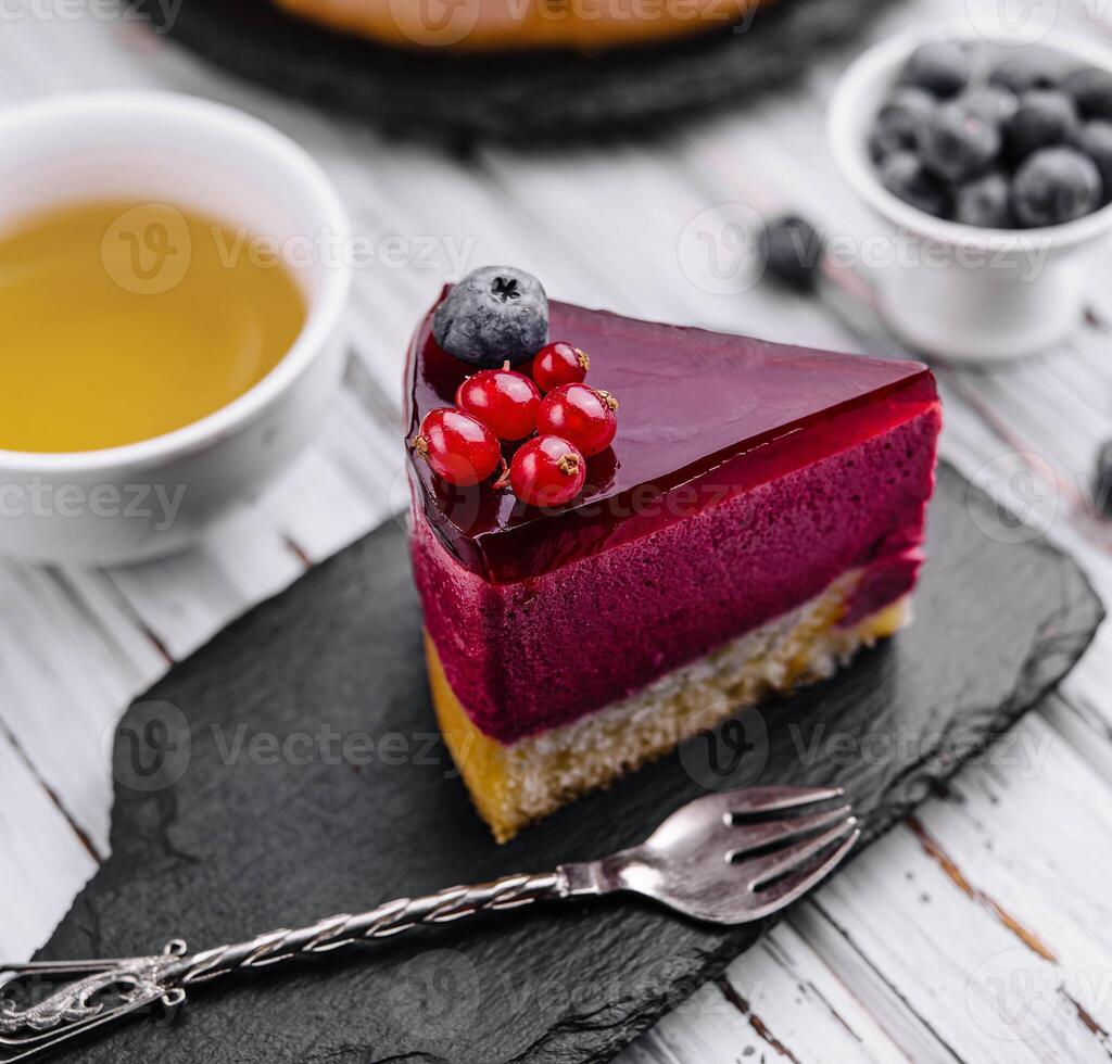 berry mousse cake with red icing and tea photo