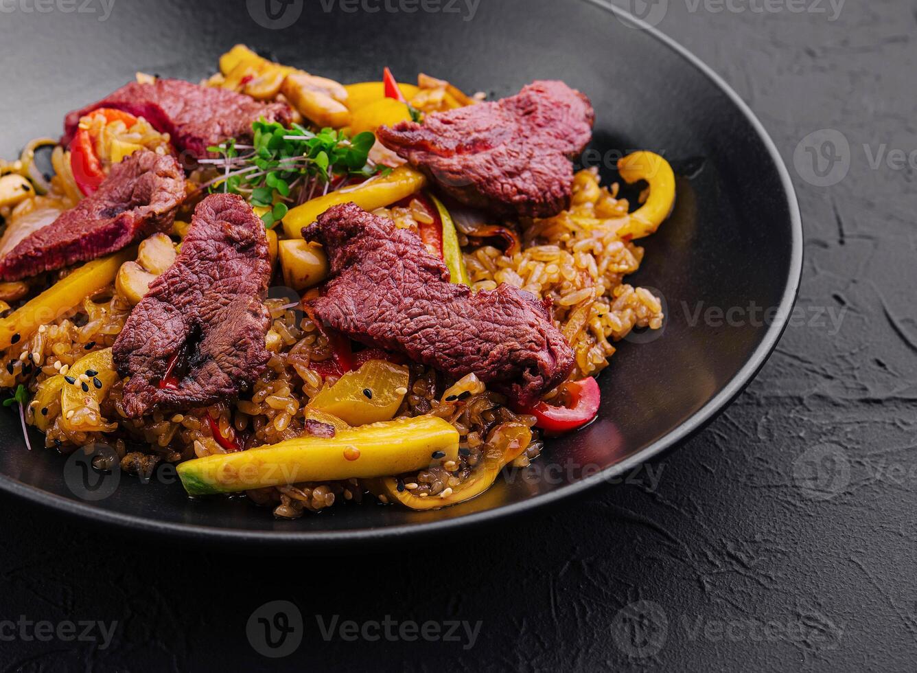 Chinese fried rice with beef on black plate photo