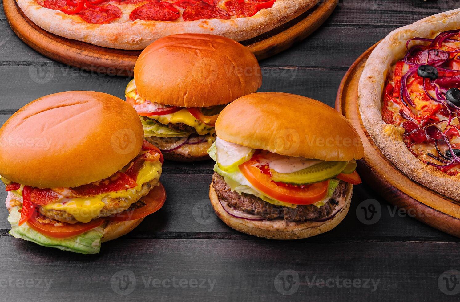 three different burgers and pizza top view photo