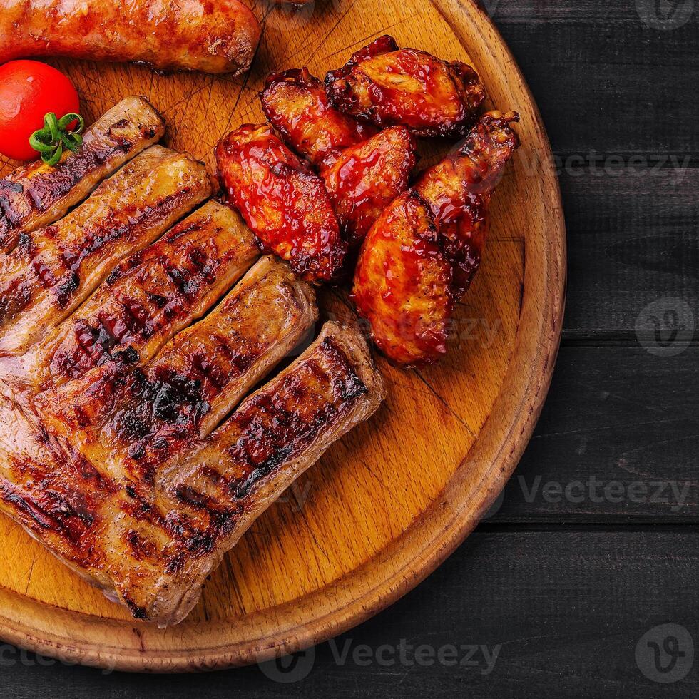 pork ribs with chicken and sausages on wooden board photo