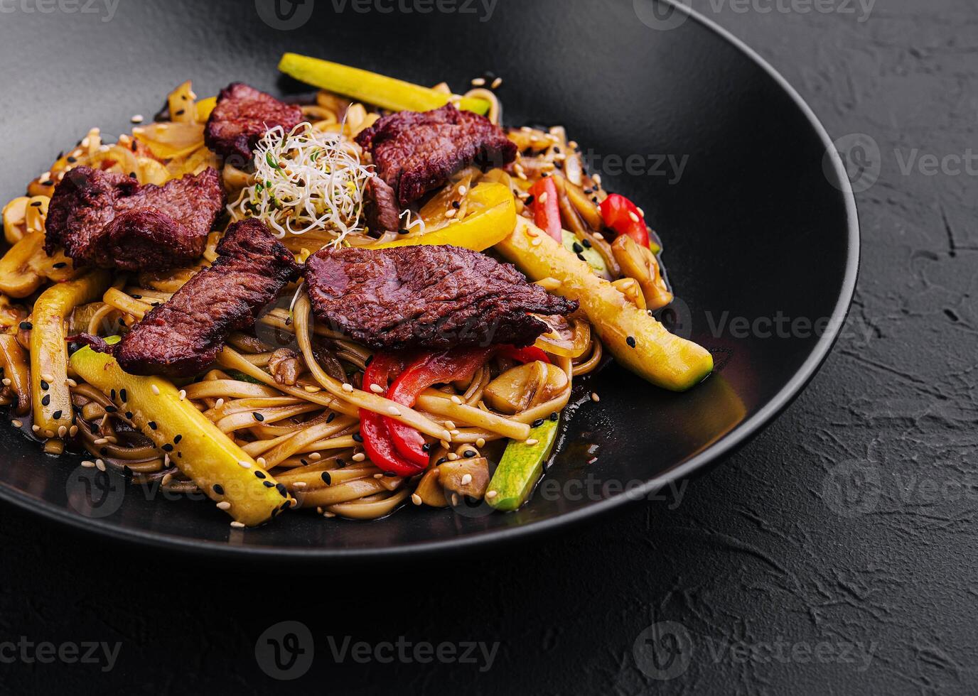Chinese noodles with roasted duck and fried vegetables photo