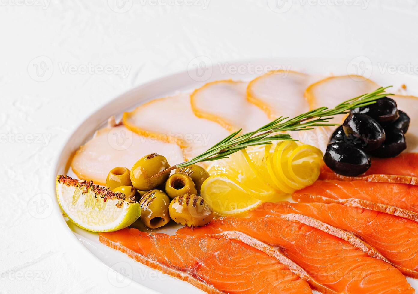 salmón, blanco pescado y aceitunas en plato foto