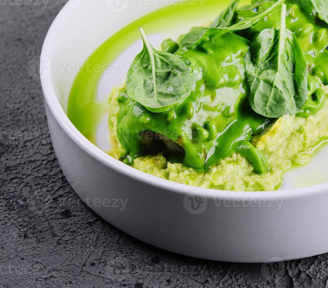 Squid with mashed avocado on stone photo