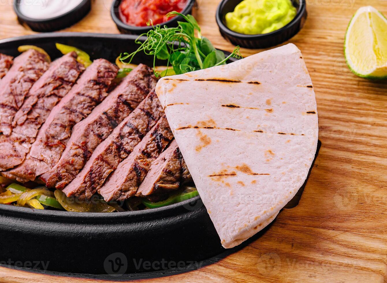 sliced fried meat with grilled vegetables and pita bread photo