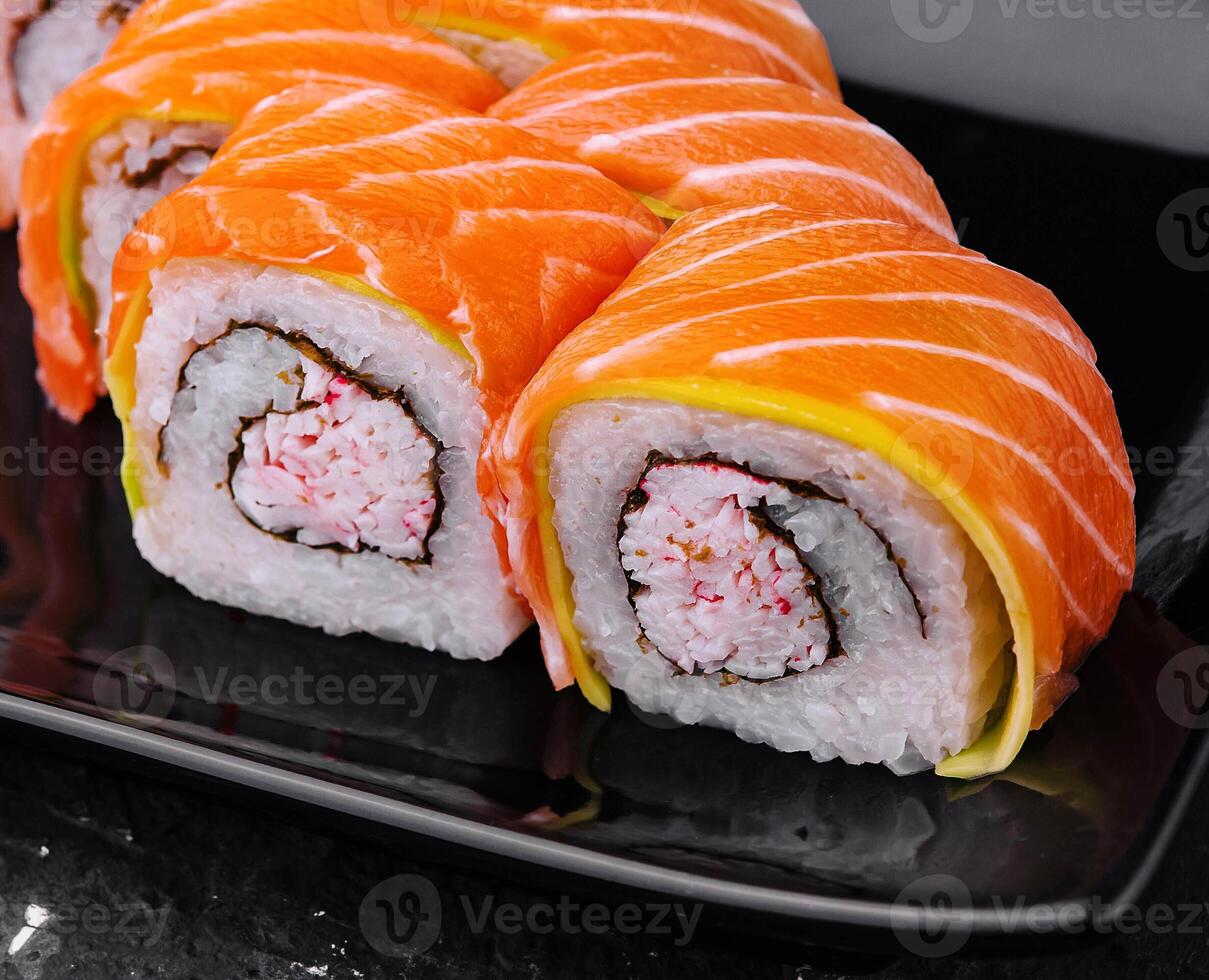 Sushi rollos con salmón y cangrejo en negro plato foto