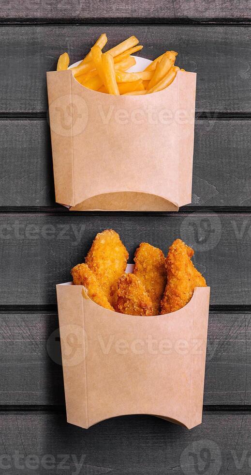 French fries and and chicken nuggets on wood photo