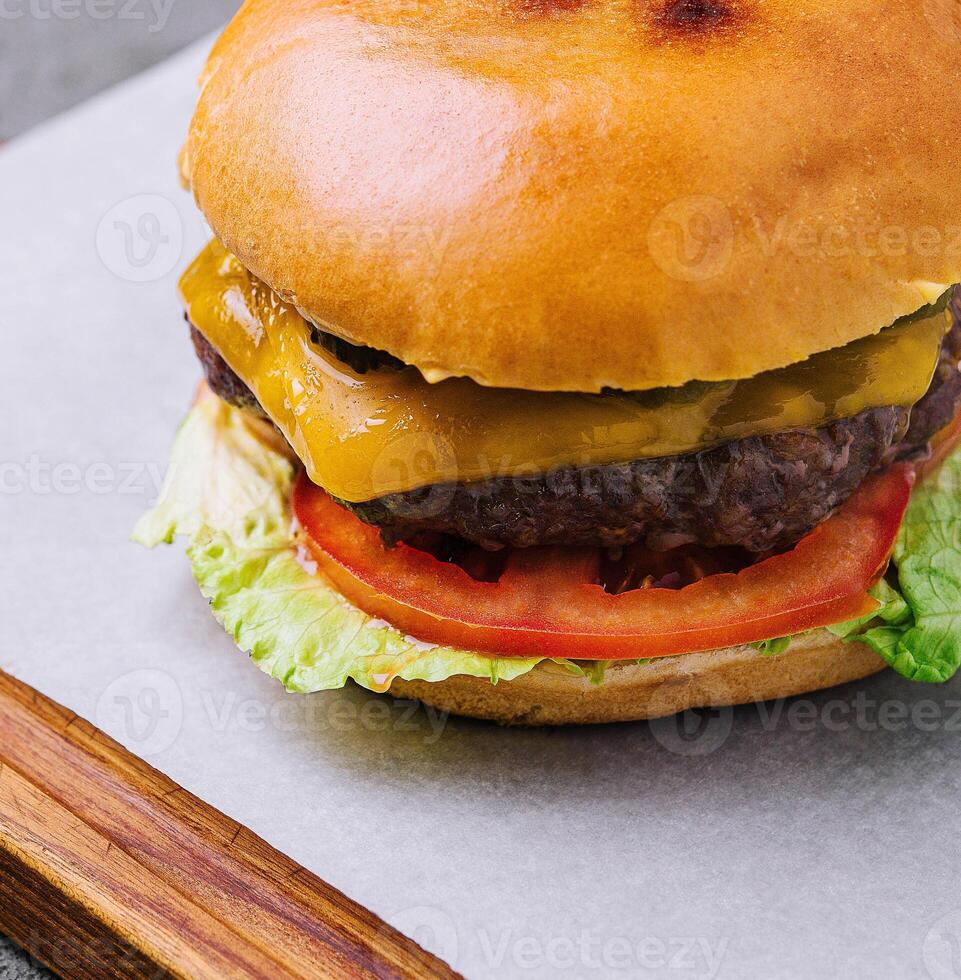 Tasty cheeseburger with lettuce, cheese and tomato photo