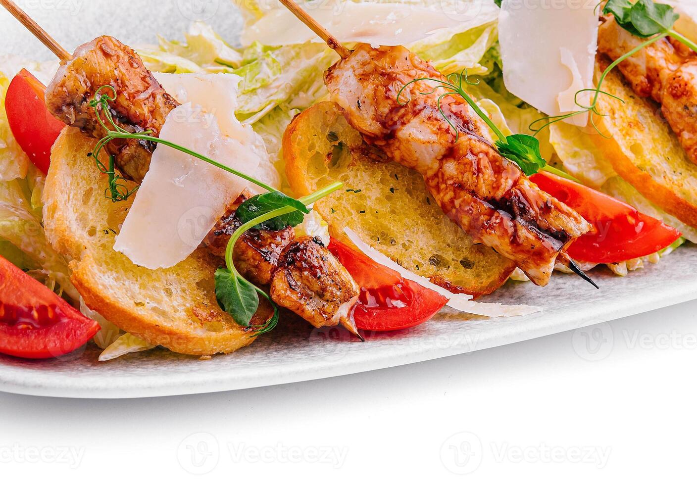 trendy Caesar salad with chicken on wooden skewers photo