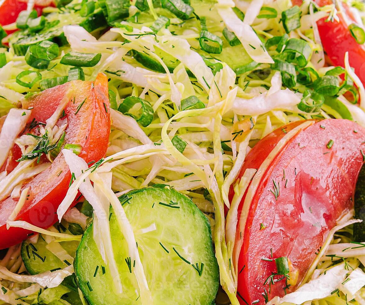 Salad from fresh cabbage, cucumbers and tomatoes photo