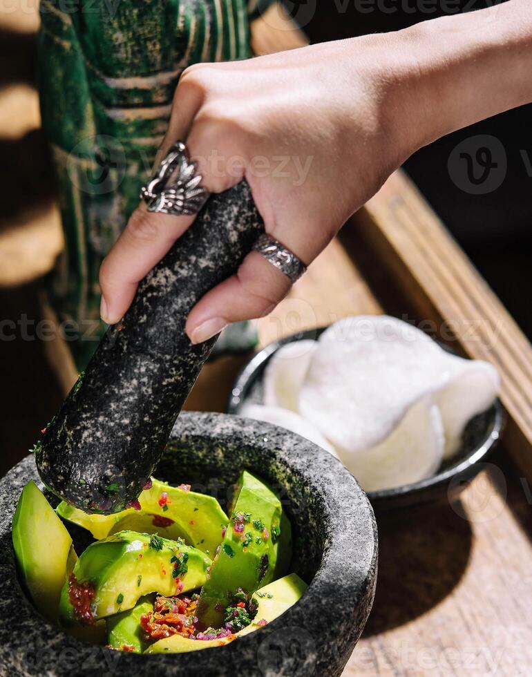 Guacamole in a mortar with rice chips photo