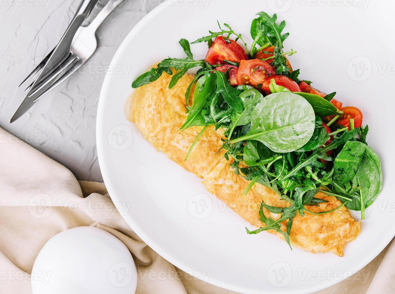 tortilla con Rúcula, Tomates y albahaca en un plato foto