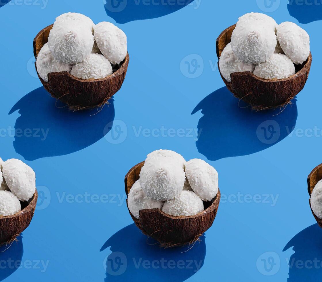 Coconuts with candies on blue table photo