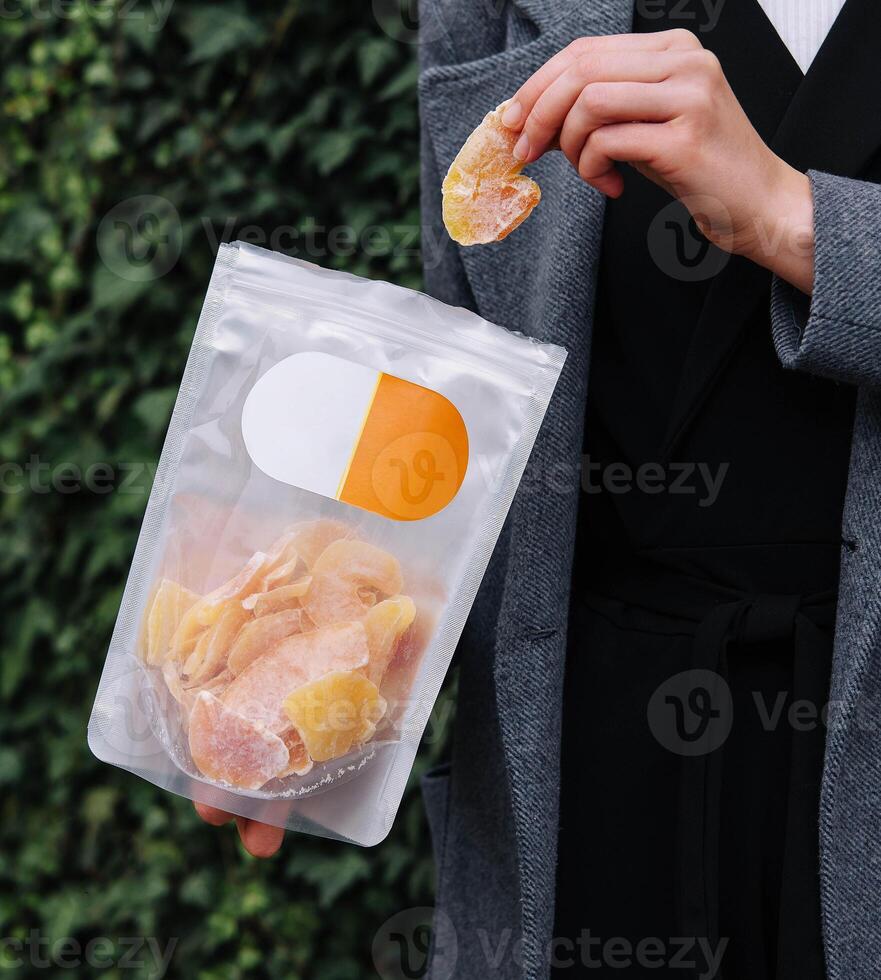 Girl Eating Dried Mango Slices photo