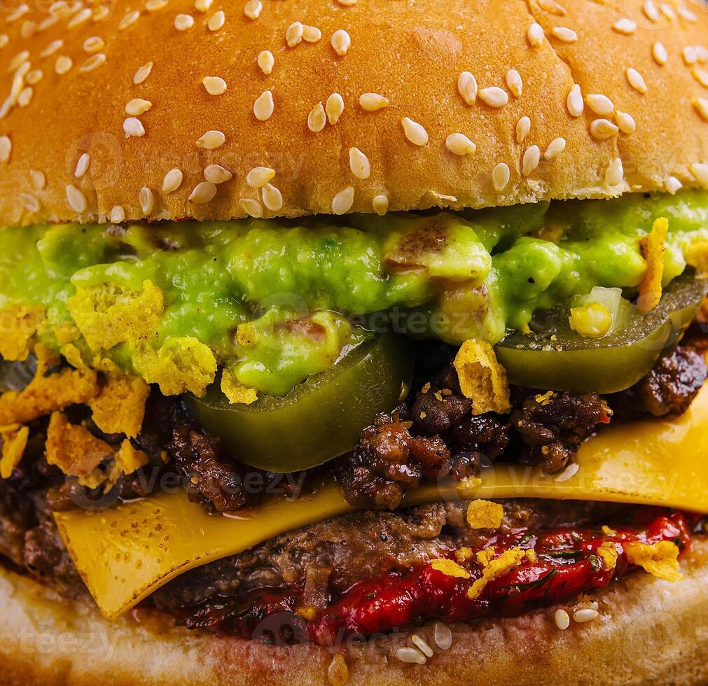 veggie burger with guacamole and pickles on toasted bun photo