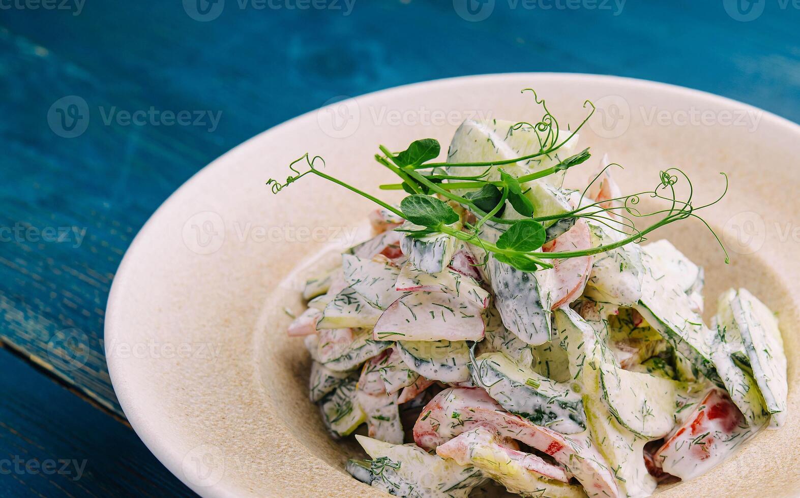 Salad with fresh vegetables and cream sause on plate photo