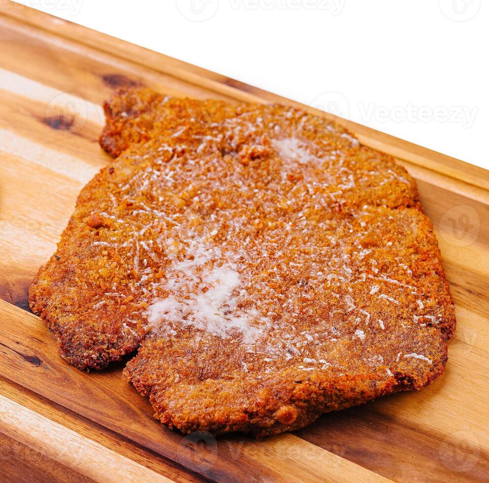 slice of Schnitzel on wooden tray photo
