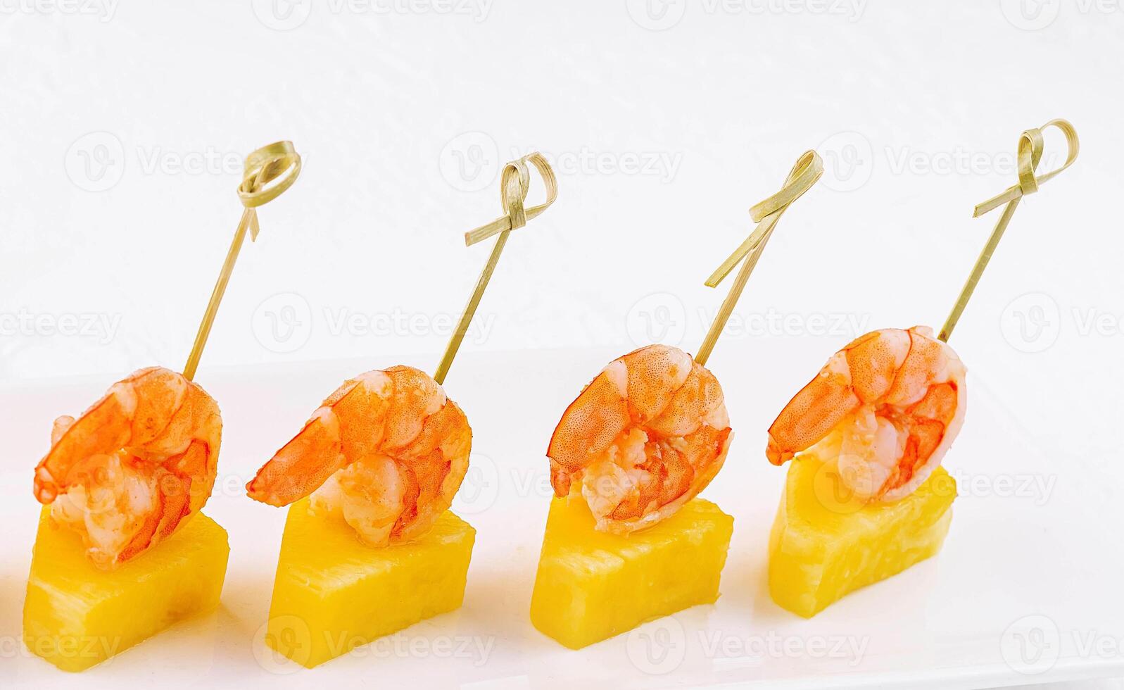 Canapes with shrimp and pineapple on plate photo