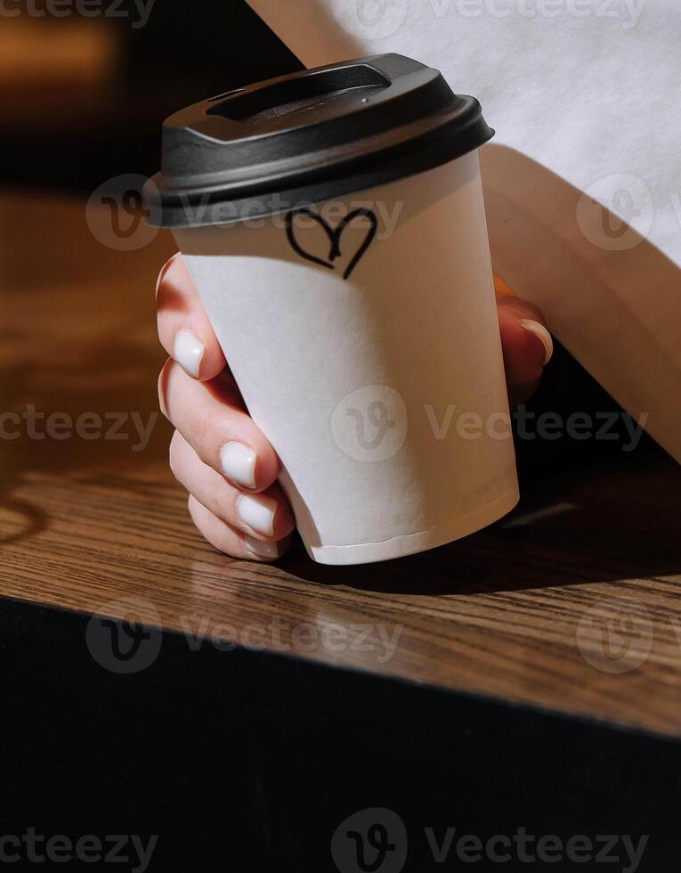 Woman holding a mug of coffee close up photo