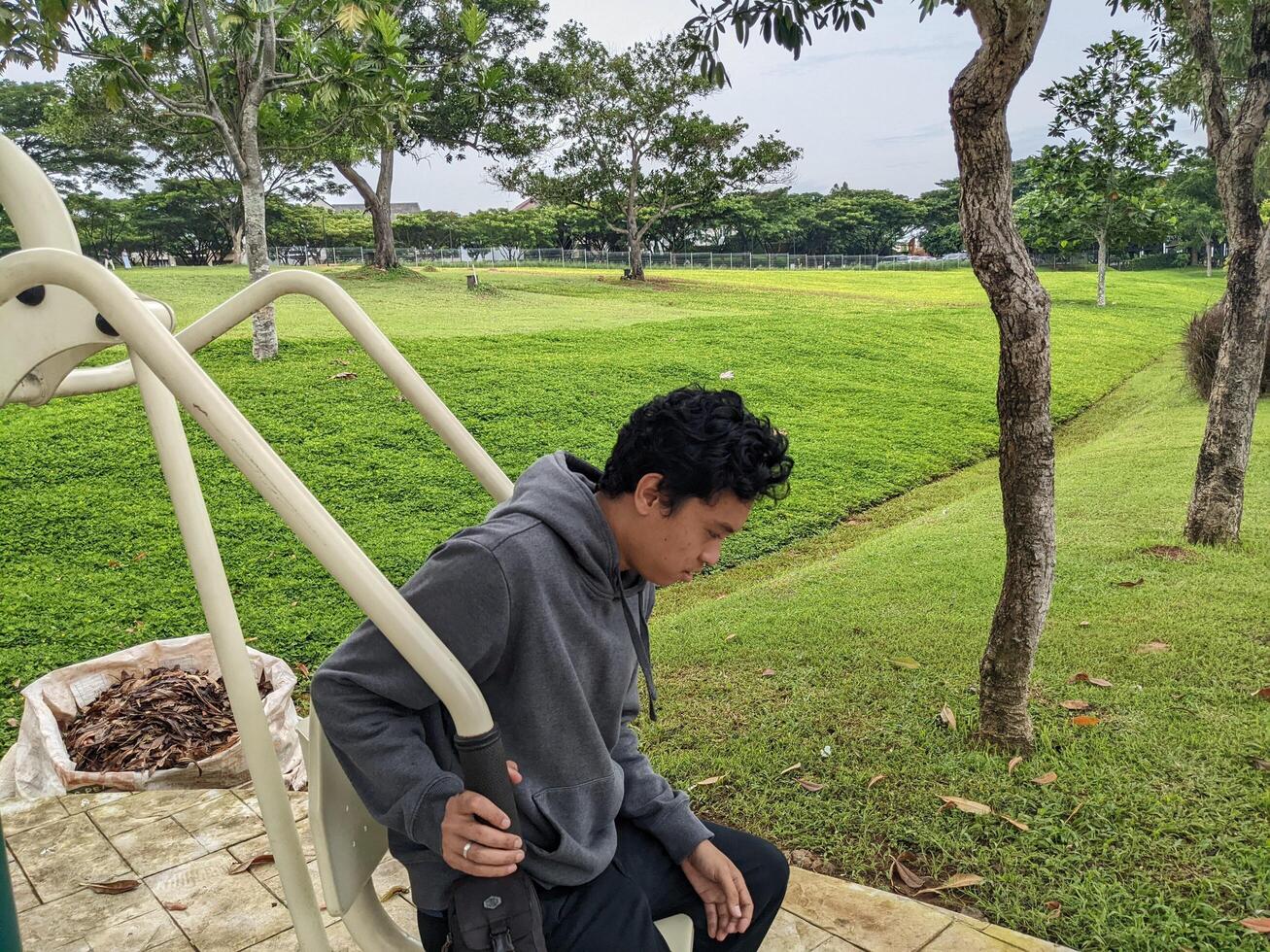 Young man are doing workout activity on the green garden. The photo is suitable to use for hobbies activity, leisure activity and park background.