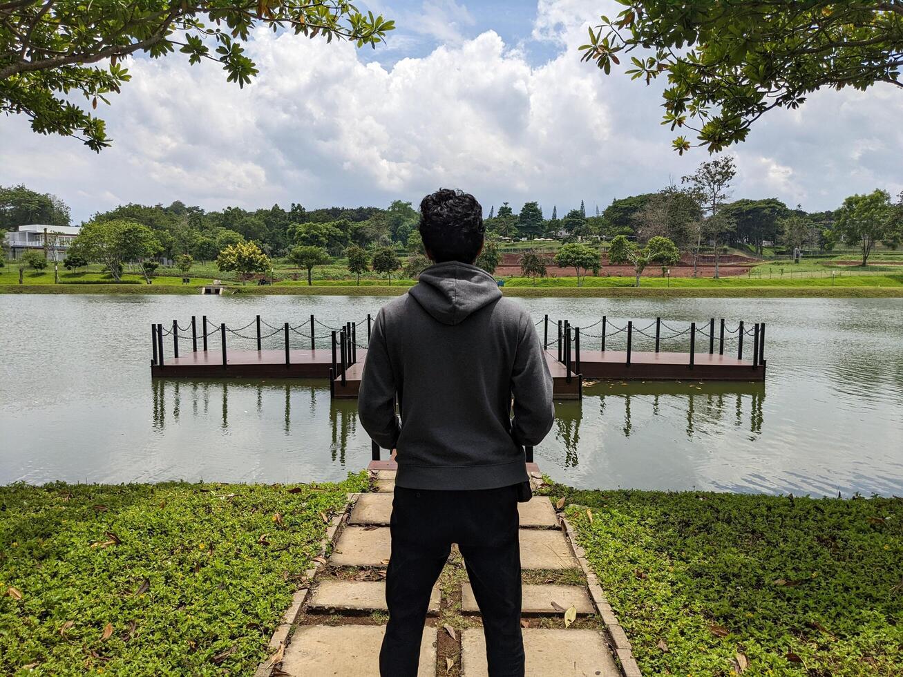 Man stand in front of the way lake on down town. The photo is suitable to use for adventure content media, nature poster and forest background.