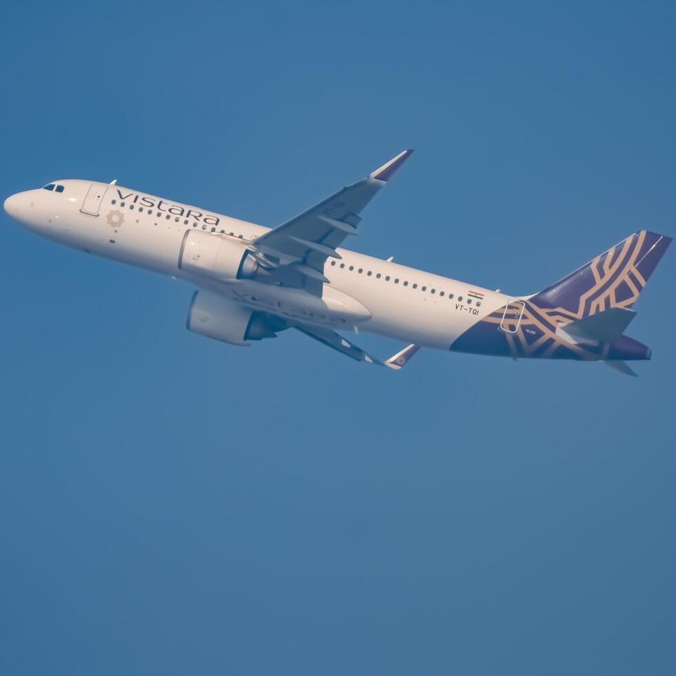 New Delhi, India, December 25 2023 - Vistara Airbus A320 neo take off from Indra Gandhi International Airport Delhi, Vistara domestic aeroplane flying in the blue sky during day time photo