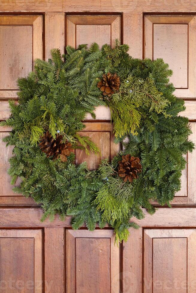 Green Evergreen Christmas Wreath On Wooden Door photo