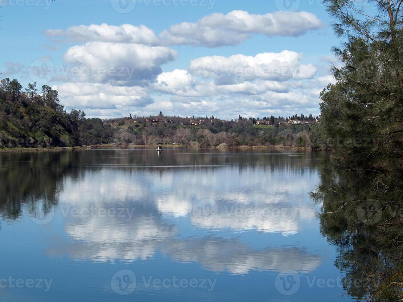 blanco nubes y azul cielo reflejado en lago foto