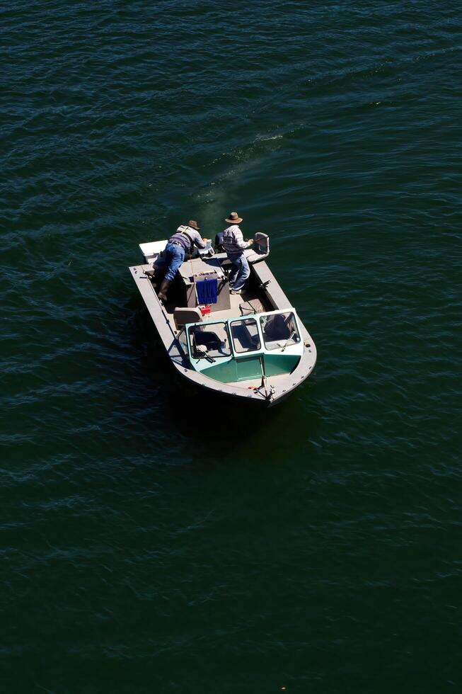 Sacramento, CA, 2012 - Two Men Fishing On Small Boat On River From Above photo
