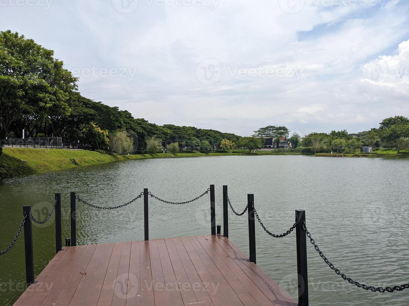 Landscape lake, track and wooden dock on BSB Semarang, Central Java. The photo is suitable to use for traveler content media, holiday background and garden poster.