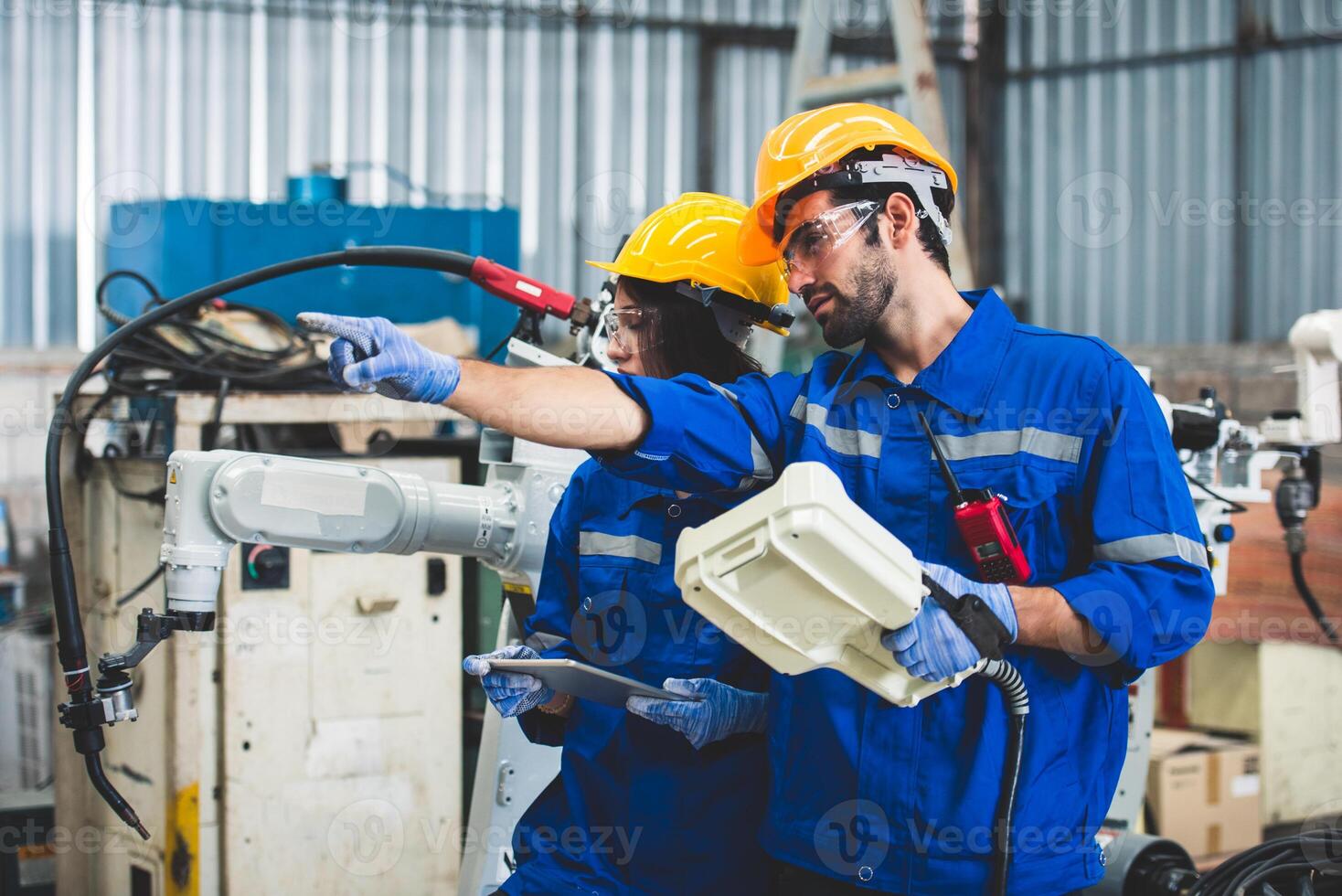 Engineers team mechanic using computer controller Robotic arm for welding steel in steel factory workshop. Industry robot programming software for automated manufacturing technology photo