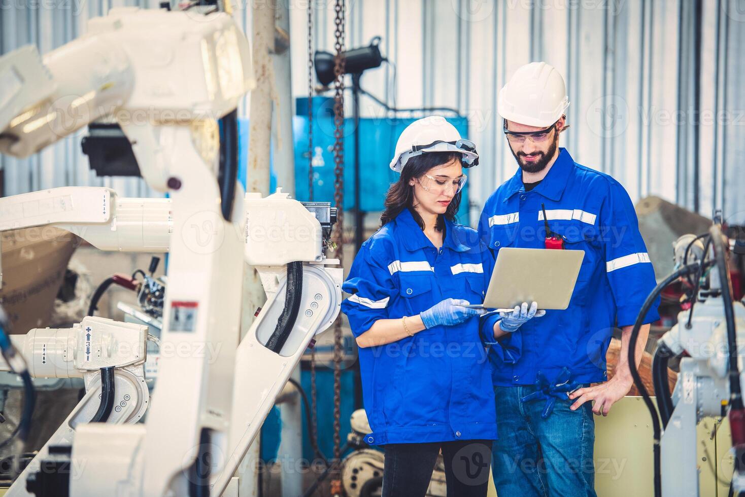 Engineers team mechanic using computer controller Robotic arm for welding steel in steel factory workshop. Industry robot programming software for automated manufacturing technology photo