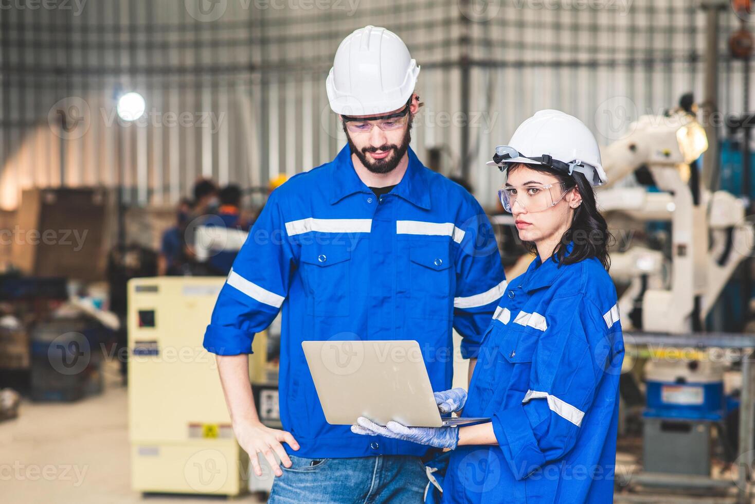 Engineers team mechanic using computer controller Robotic arm for welding steel in steel factory workshop. Industry robot programming software for automated manufacturing technology photo