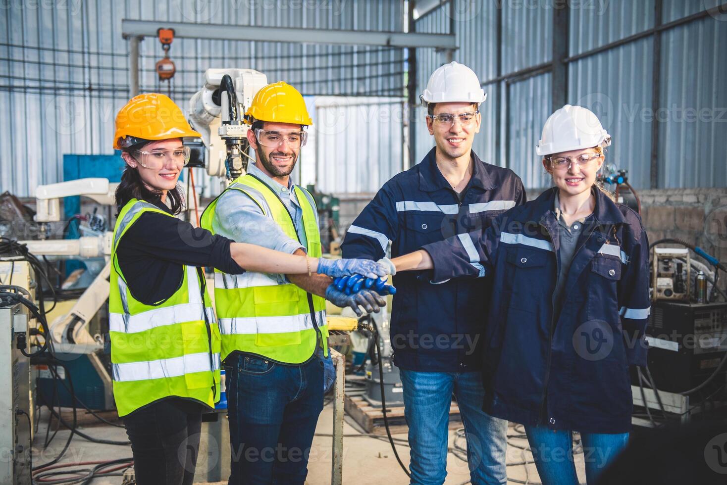 Engineers team mechanic making pile of hands in steel factory workshop. Industry robot programming software for automated manufacturing technology photo