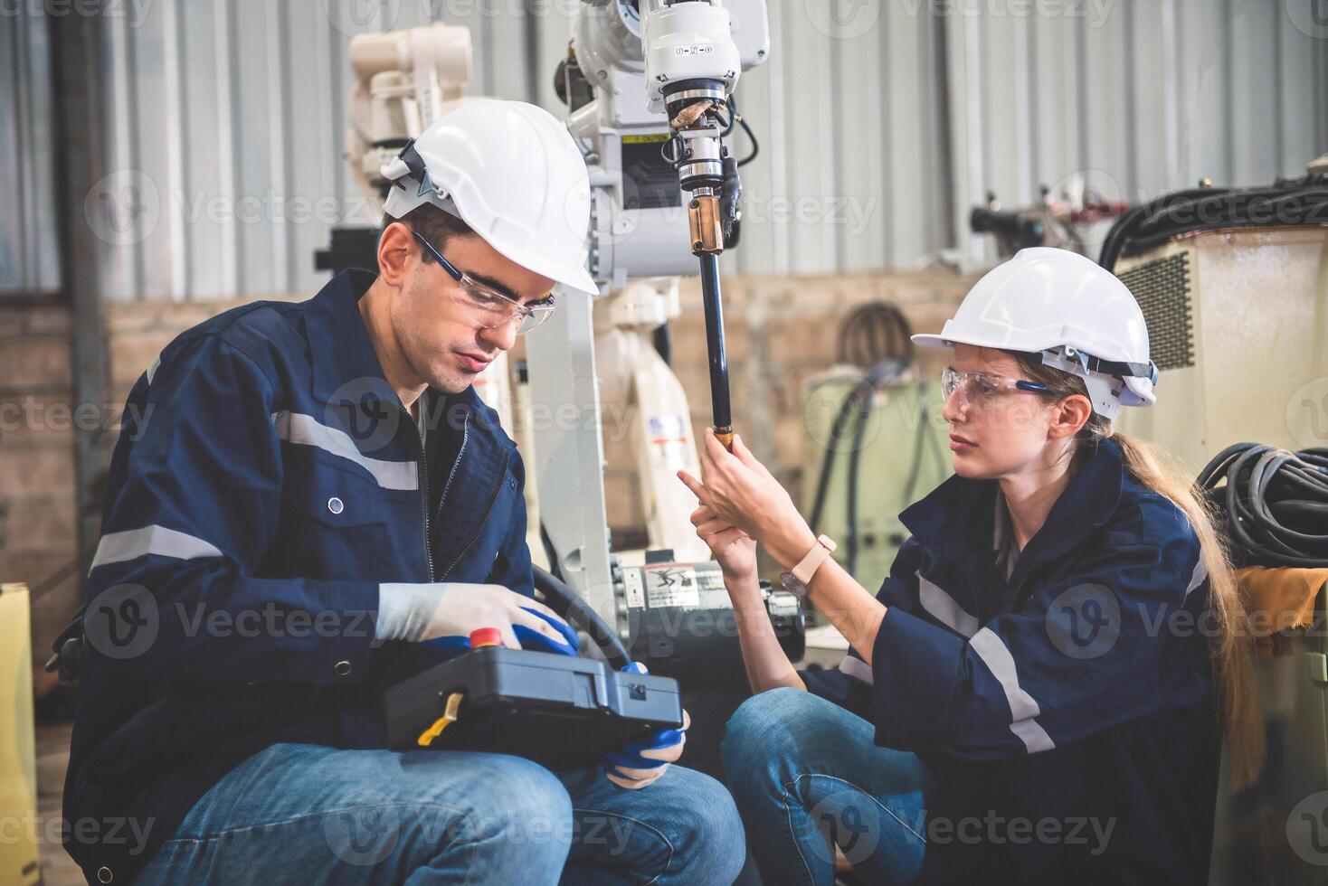 Engineers team mechanic using computer controller Robotic arm for welding steel in steel factory workshop. Industry robot programming software for automated manufacturing technology photo