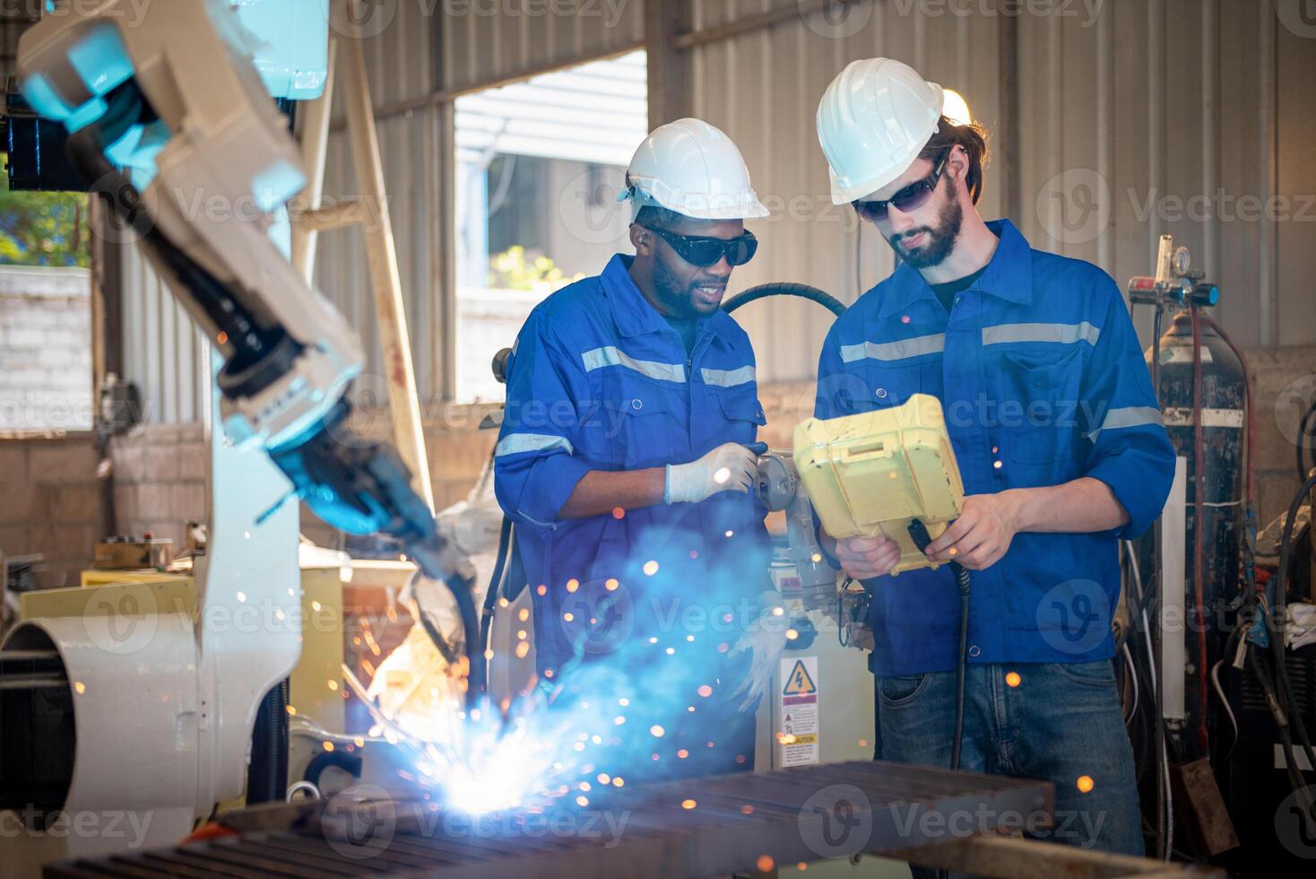 Two engineers mechanic using computer controller Robotic arm for welding steel in steel factory workshop. Industry robot programming software for automated manufacturing technology . photo