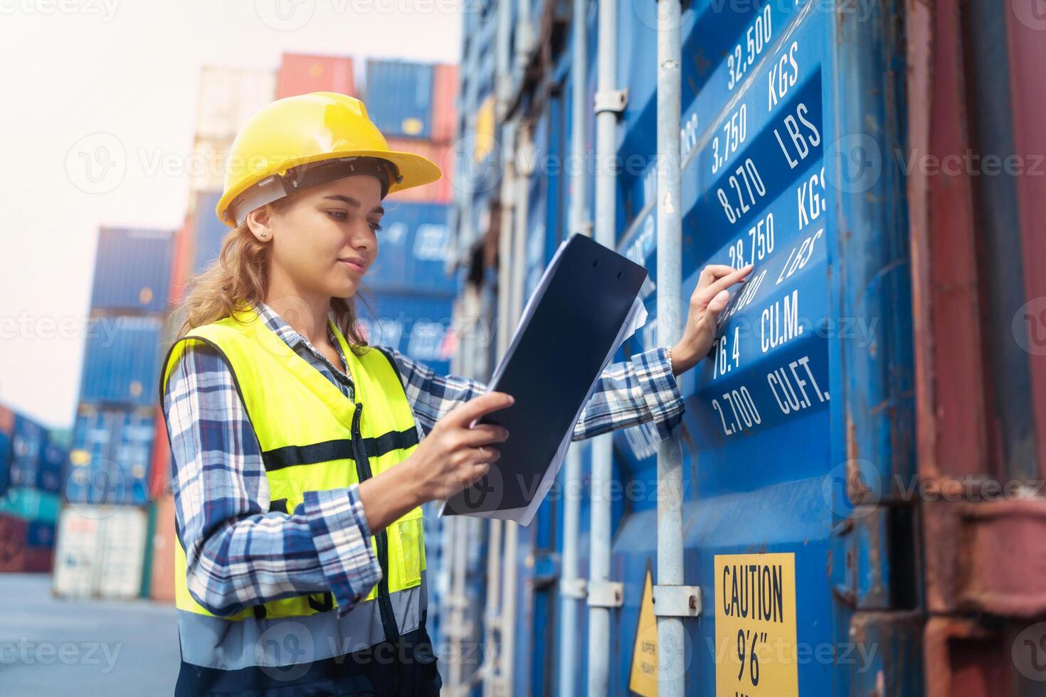 Women Engineer wears PPE checking container storage with cargo container background at sunset. Logistics global import or export shipping industrial concept. photo