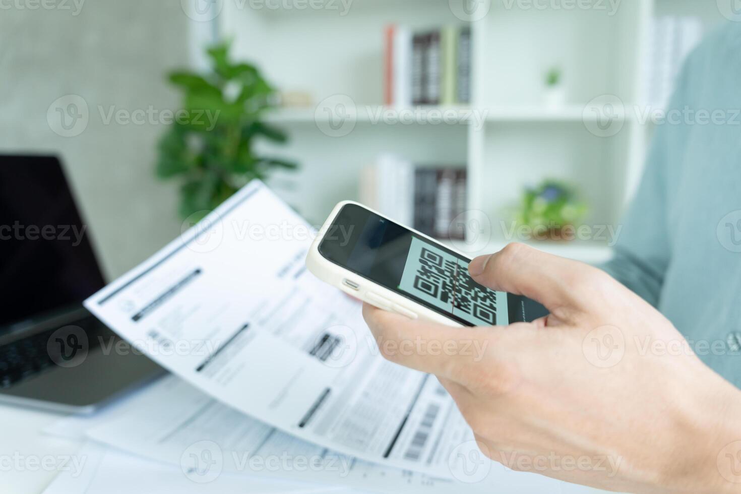 business man use phone to scan barcode or QR codes to pay credit card bill after receiving document invoice online. payment, receive, paying electricity, digital payments without money, technology photo