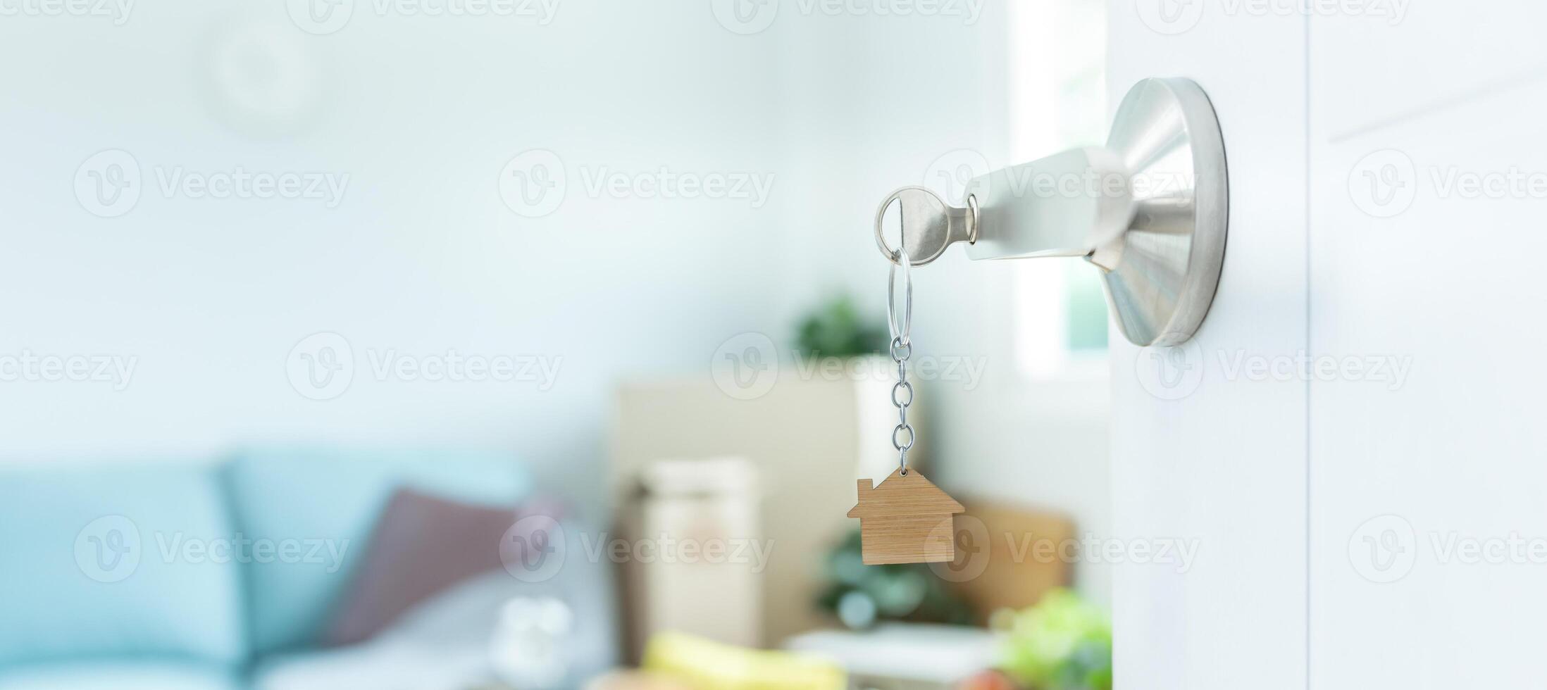 Moving house, relocation. The key was inserted into the door of the new house, inside the room was a cardboard box containing personal belongings and furniture. move in the apartment or condominium photo