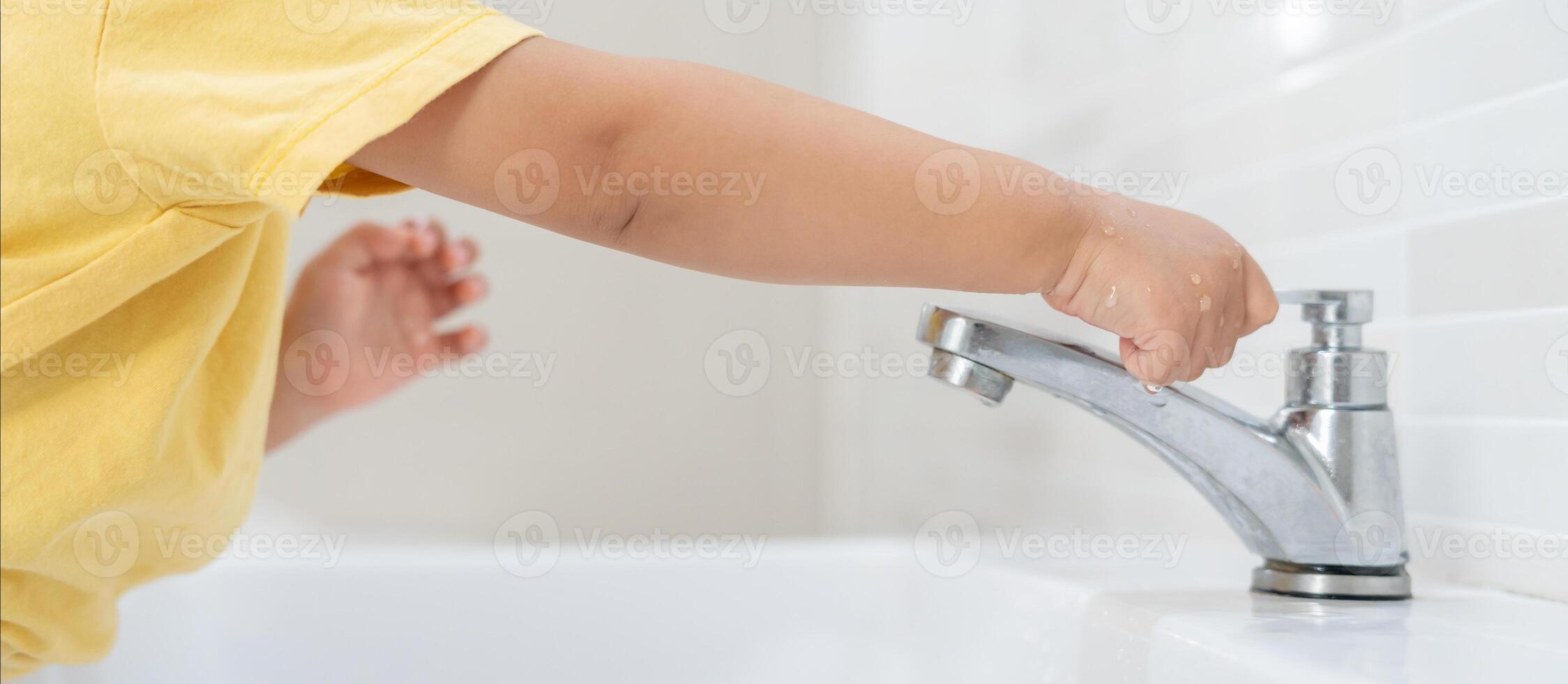 Little kid keeps turning off the running water in the bathroom to protect environment. Greening planet, reduce global warming, Save world, life, future, risk energy, crisis , water day. photo