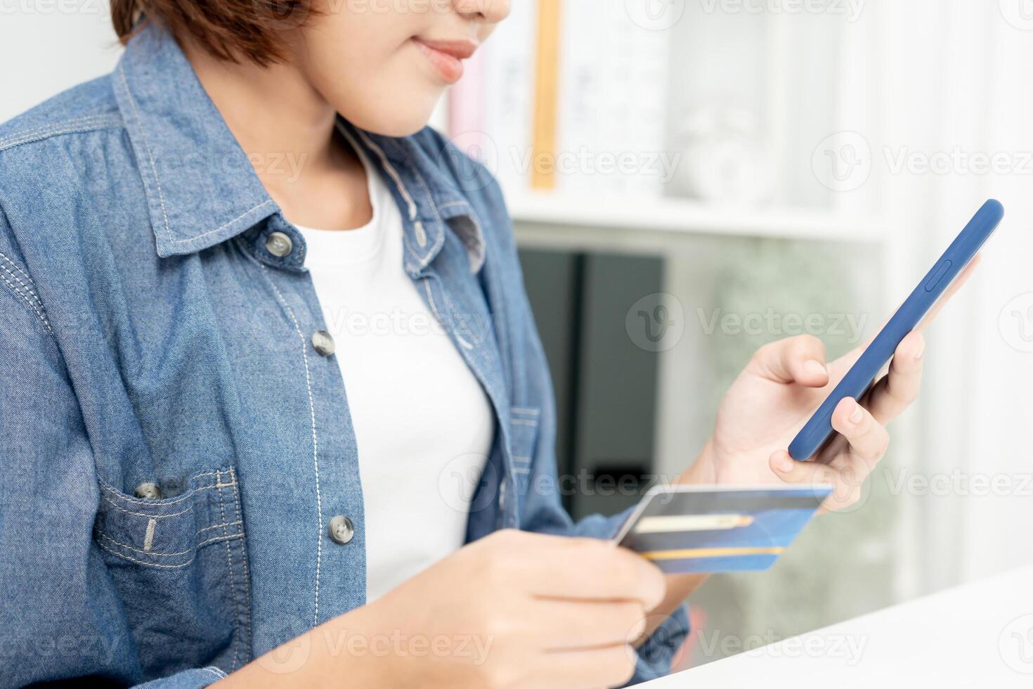 woman using smartphone for online shopping at home. Hand holding mobile phone with payment detail page display and credit card, stay home, technology, electronic commerce, internet, market place photo