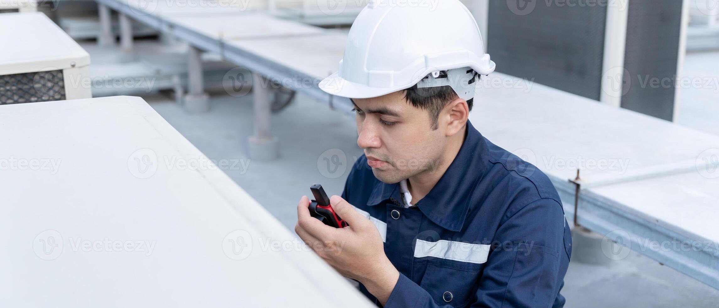 Asian maintenance engineer work on the roof of factory. contractor inspect compressor system and plans installation of air condition systems in construction. technology, walky talky, maintenance photo